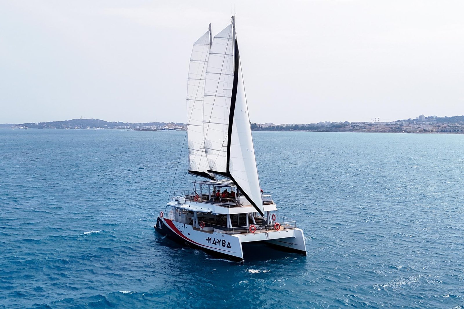 Mayba sailing catamaran crossing calm water off the Riviera coast